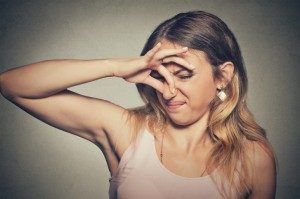 woman pinching her nose because of a bad smell